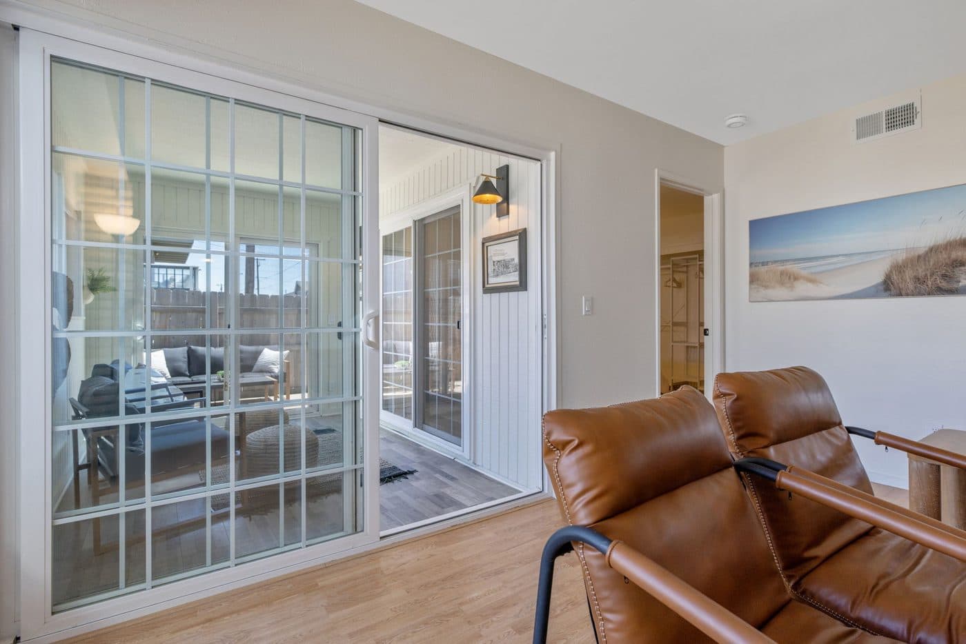 Sunroom seating area with leather chairs and views out to the dunes