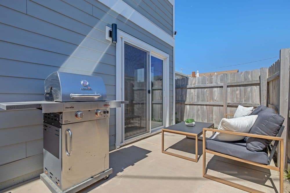 Private back patio with outdoor seating and a gas grill