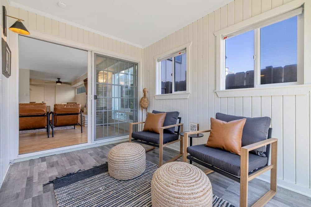 Downstairs sunroom with glass walls opening onto the back patio